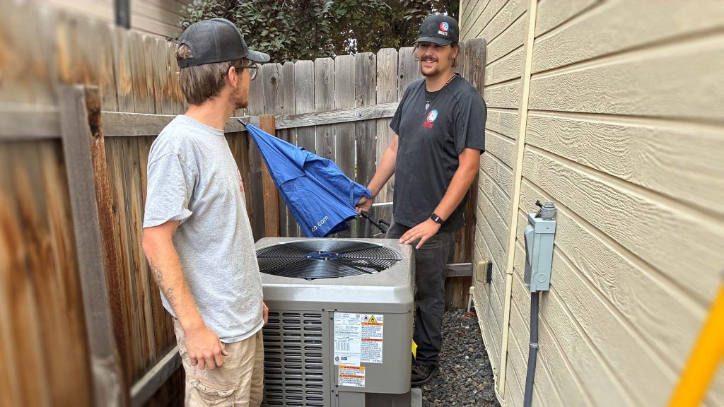 Technicians placing A/C unit